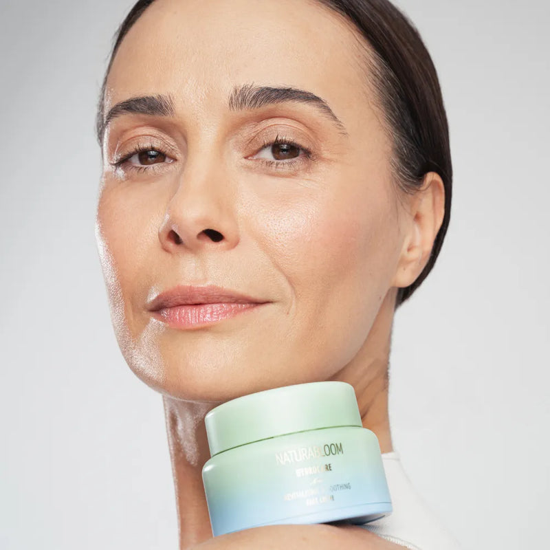 Woman with clear, hydrated skin holding NATURABLOOM Hydrocare moisturizing face cream